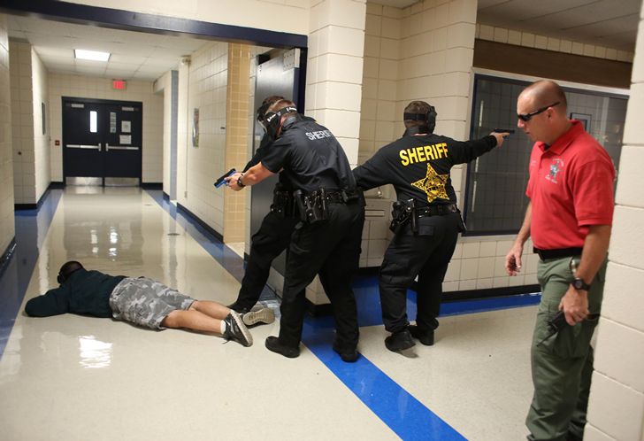 In this stock photo, Sheriffs fan out over an East Coast high school hallway during an active shooter drill. 