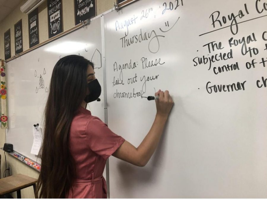 Ms. Yaquelin Montiel, once reading these whiteboards at CHS, is now writing on one in preparation for her students.