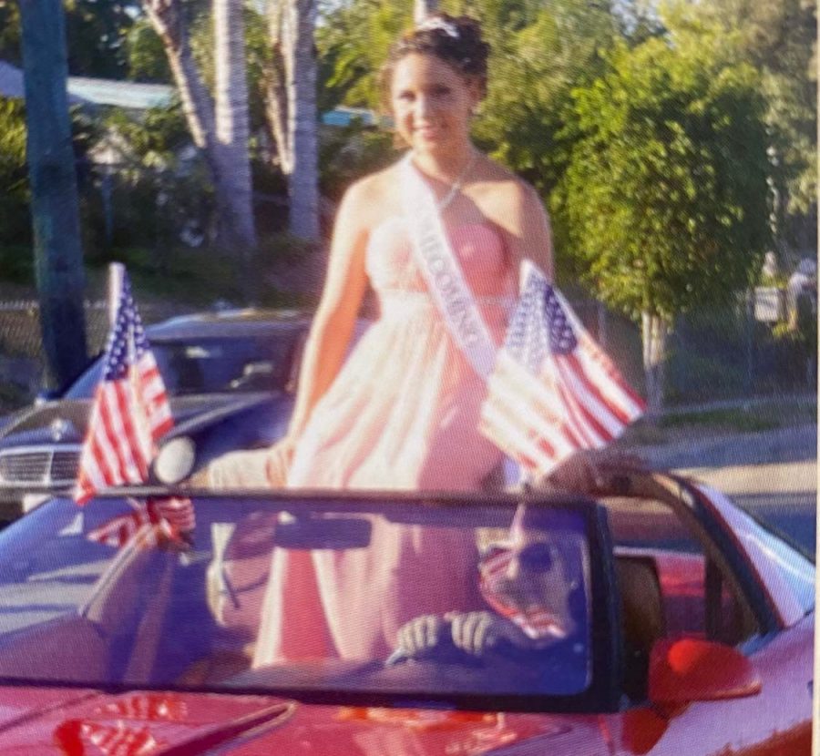 Homecoming Queen Katya Dominguez enters the parade route seated regally in a convertible Corvette during the 2013 Homecoming Parade.