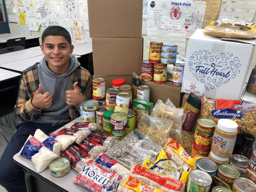 CROSS Club President Anthony Gomez gives the thumbs up for this years collection of canned goods. CROSS Club led the charge to resume the annual Canned Food Drive this year.