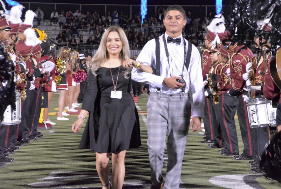No matter how busy she is with family, school, and work, Leslie Cruz still takes the time to support students. Here she is, escorting senior Homecoming Court 
nominee Anthony Garcia during halftime of the 2021 Homecoming game.