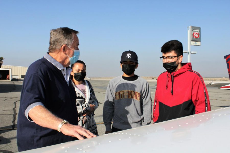 Pilot Ken Leyva teaches Leonardo Norzagaray and Edgar Lomas about fuel supply in a private aircraft.