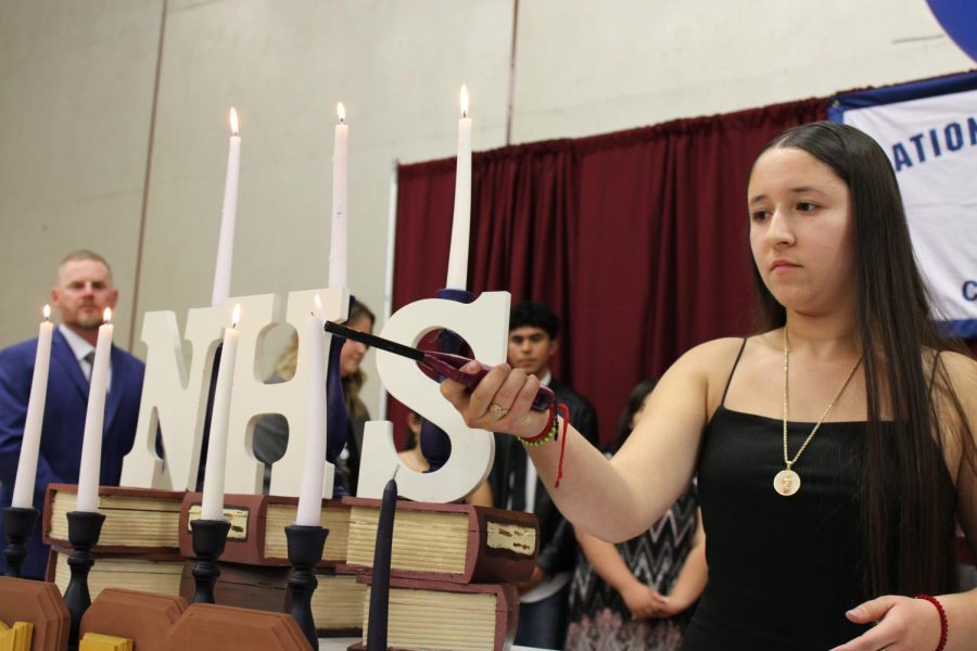 NHS Treasurer Ruby Alvarez lights a candle symbolizing service at the NHS Induction ceremony on Apr. 27.