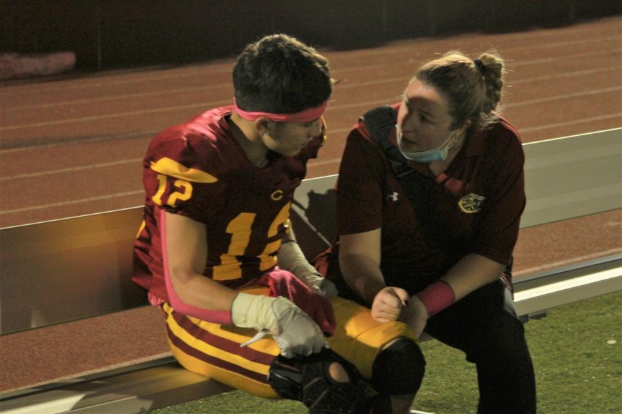 Athletic Trainer Megan Kelley discusses health and safety with Steven Medina during a timeout.
