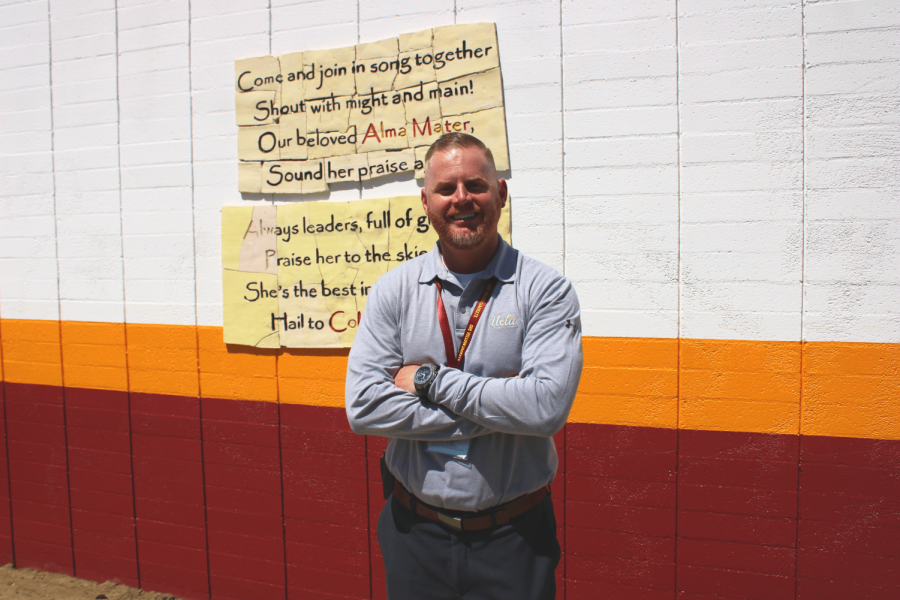Principal John Abbott stands in front of a sample of the paint job coming to Colton High this summer. This paint is a more traditional mix of Coltons crimson, gold, and white color scheme.