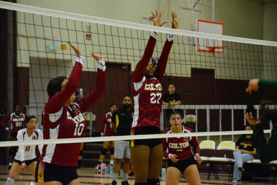 Alyssa Gonzalez and Jayda Porter jump at the net during the first set against Perris.