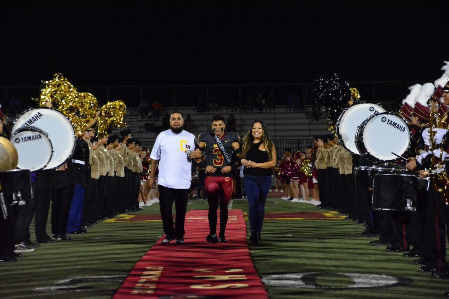 Gabriel Aparicio, escorted by his parents, takes to the red carpet at halftime, already happy the Yellowjackets are ahead 16-0 over Fontana.