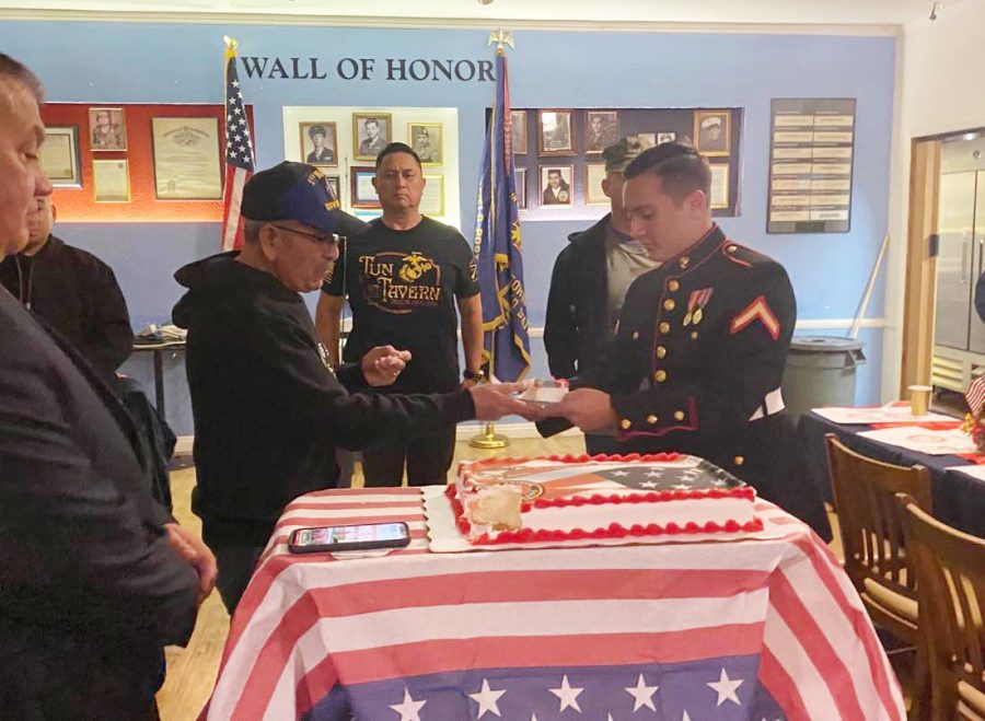 Elder Marine Rudy Ramirez passes the ceremonial cake to recent enlistee Joshua McPherson in annual Marine Corps birthday ceremony at the Colton VFW on Nov. 10, 2022.