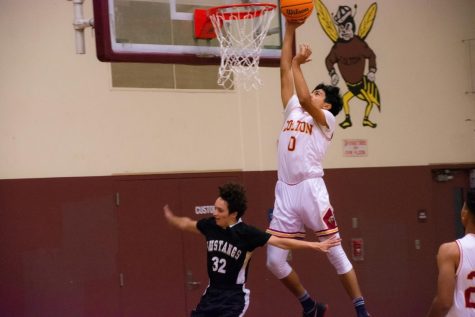 Aaron Valencia skies to the hoop for a basket during his 12-point first quarter outburst. He finished the game with 16 points in Coltons dominant 81-25 victory over Lucerne Valley.