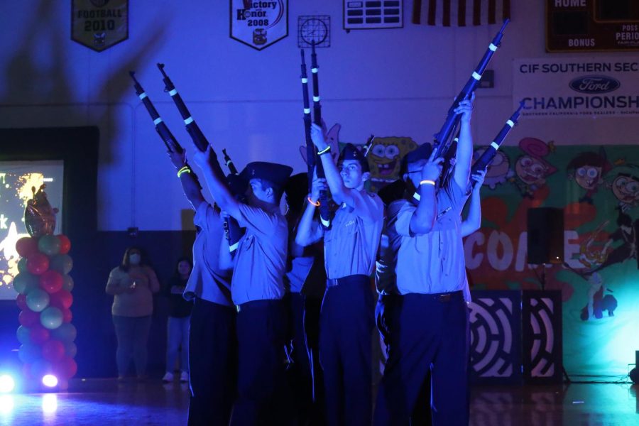 Lieutenant Commander Monique Velasco and her ROTC platoon improvised this gun salute stunt near the end of their performance at the pep rally. It was a successful gambit. The crowd went wild.