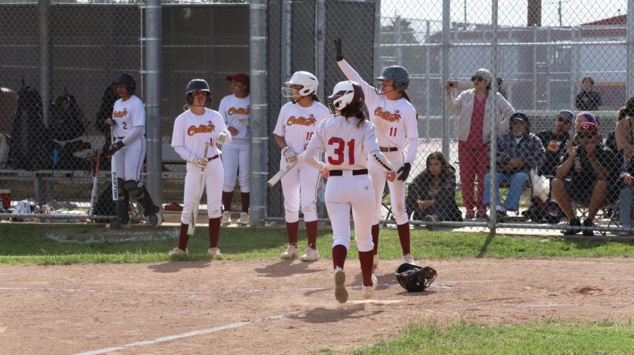 Coltons softball team celebrates a run in the fourth inning.