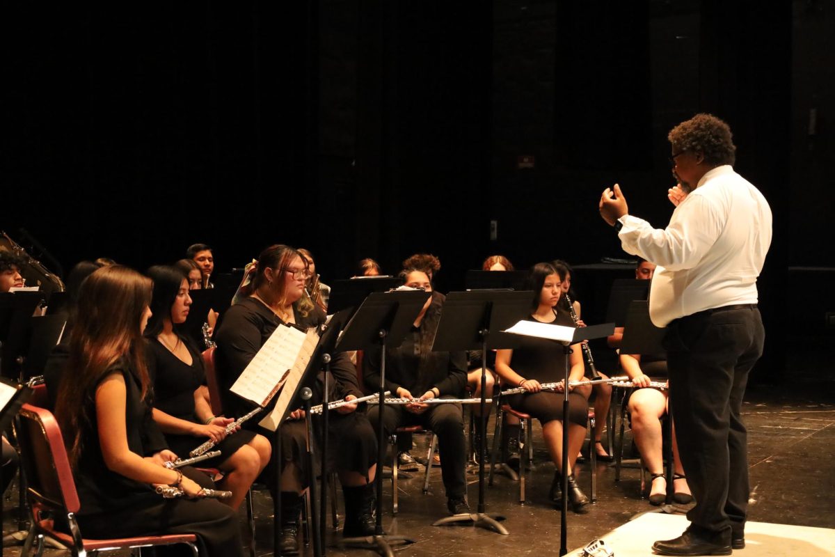 Band Director Aron Campbell conducts the Wind Ensemble through their first song Marching Song.