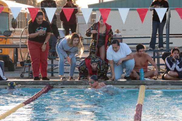 August Castillo is cheered on by her team as she makes her turn in the 100 breaststroke.