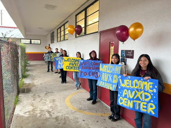 AVID and AVID Club students line up in a row with welcoming signs and happy greetings as they wait for the AVID evaluators to arrive at CHS. 