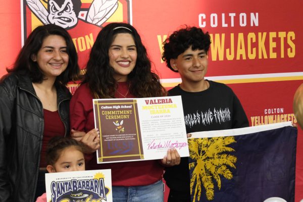 Senior Valeria Moctezuma poses with her mom and younger brother, showing off her commitment signature after the ceremony. 