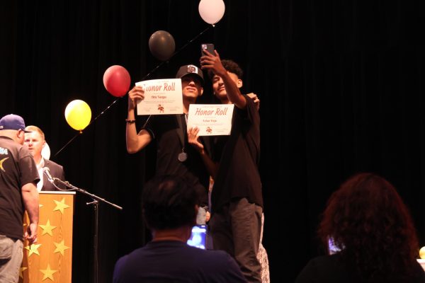 Students Otis Vargas and Lelan Trejo pose for a picture together after both receiving Honor Roll up on stage.