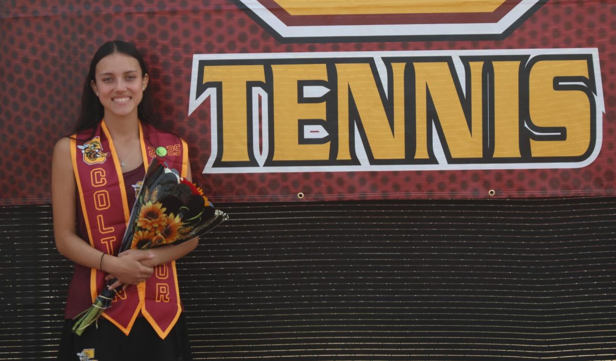 Senior Emily Prada poses with the Tennis banner and her flowers at Senior Night