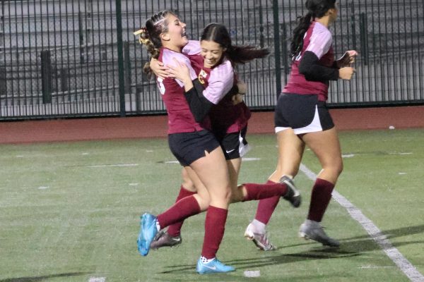 Seniors Cambria Duron and Adalyn Moreno celebrate Moreno's second half goal in the Yellowjackets 3-0 win over Bloomington High.