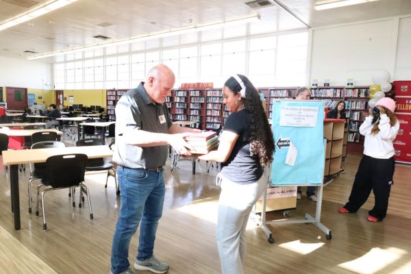 After losing his home of 52 years in the Eaton fire, Colton High's publications department replaced Kenny Wilson's high school yearbooks. Freshman Gennasy Pohlman did the honors of presenting Wilson with the gift.