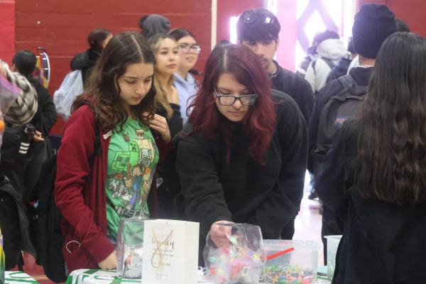 Two sophomores pick a prize from one of the wellness booths as they listen to the booth speaker