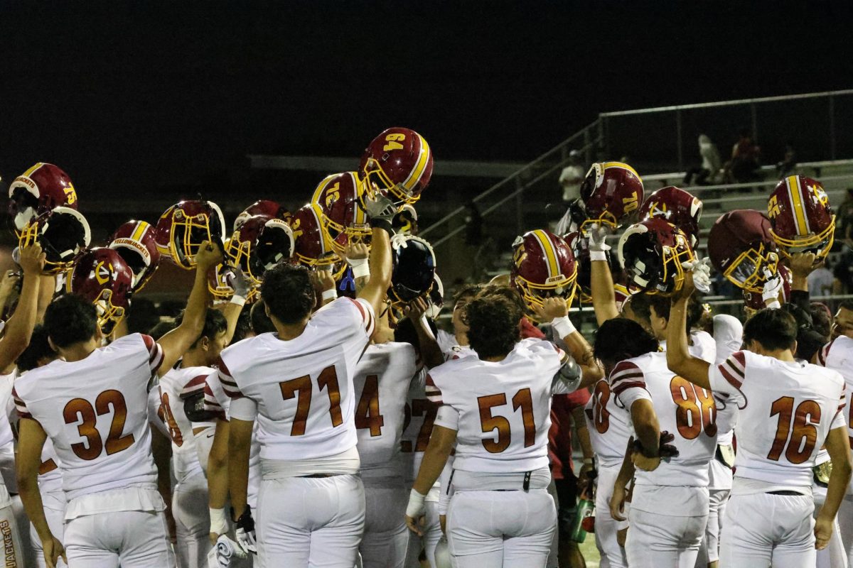 Colton holds their helmets high in celebration of their first victory of the 2025 season over Jurupa Valley, 61-0.
