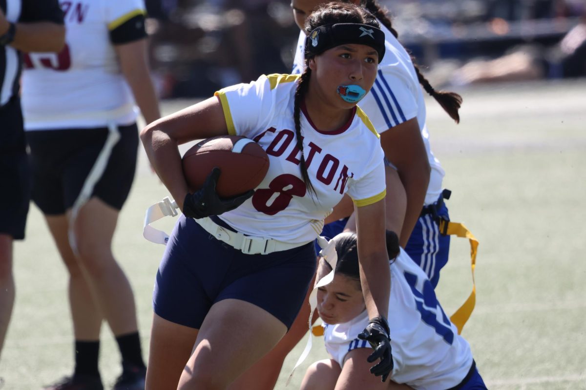 Junior Heidi Alarcon rushes through the Alta Loma defense during the first ever flag football game for Colton High.