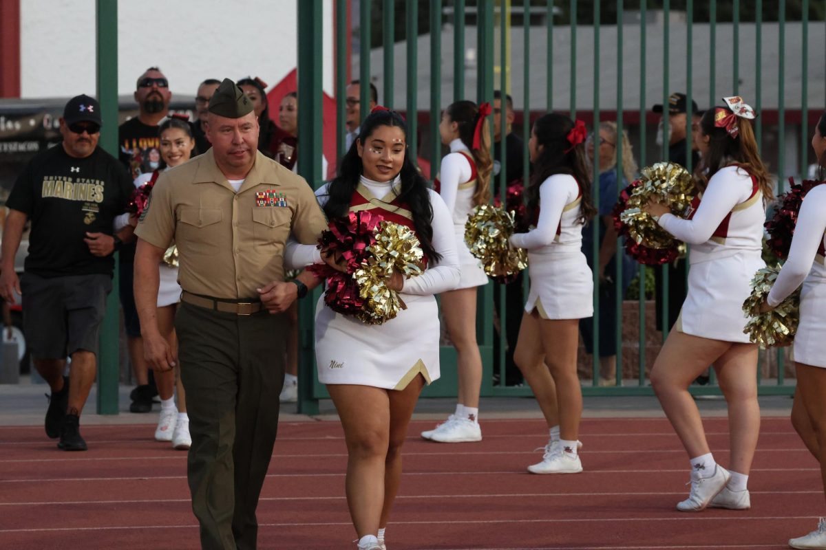 Before the game, Colton celebrated Veterans and First Responders Night. Sgt. Major Jorge Melendez, ROTC teacher, is escorted onto the field by cheerleader Anissa Lopez. 