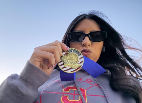 Mia Guerrero shows off her medal from the Freedom Invitational in March, where she set a personal record of 91 feet, 7 inches in the discus.